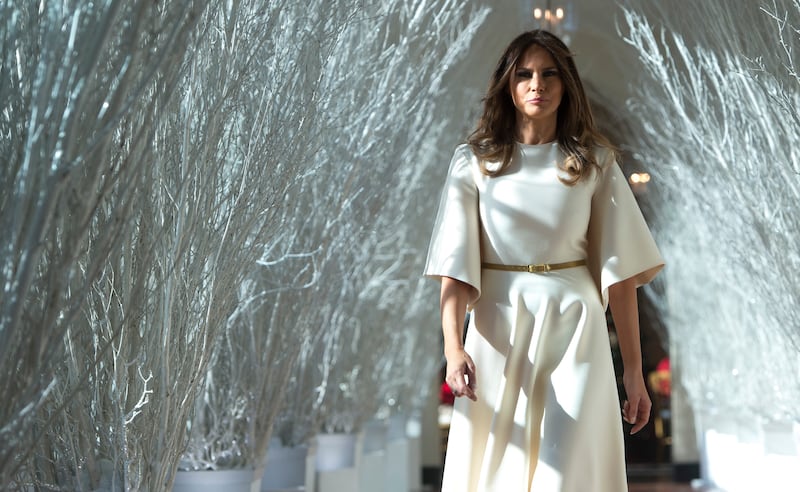 First Lady Melania Trump walks through Christmas decorations in the East Wing as she tours holiday decorations at the White House in Washington, DC, on Nov. 27, 2017.