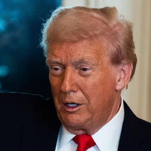 Donald Trump holds up a model of his new arc