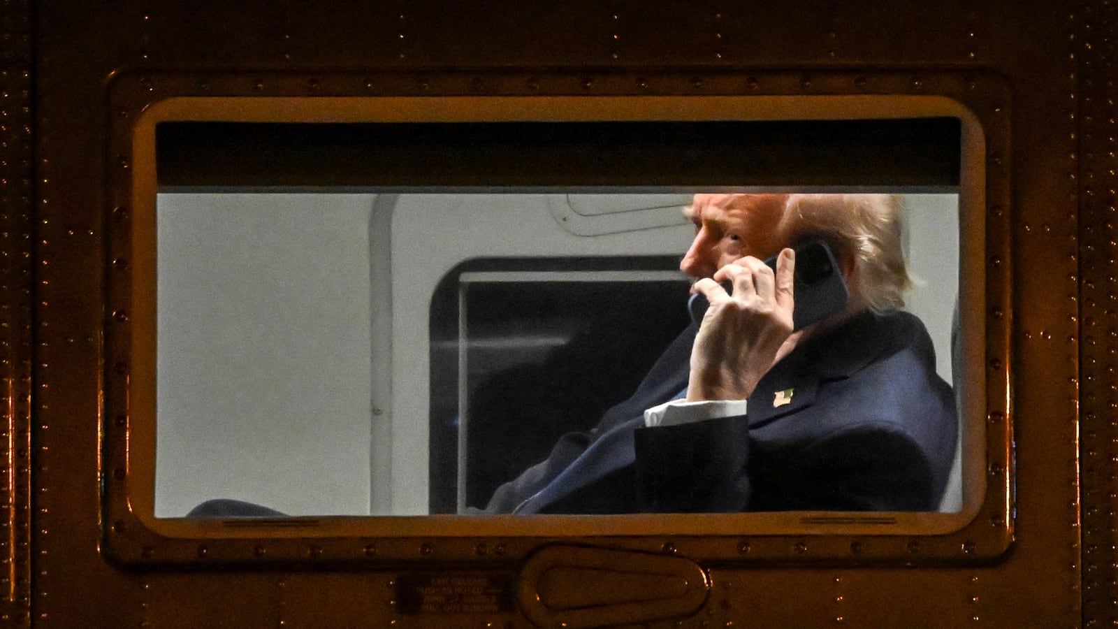 President Donald Trump uses a cellphone aboard Marine One before it departs Leesburg Executive Airport in Leesburg, Virginia, on April 24, 2025.