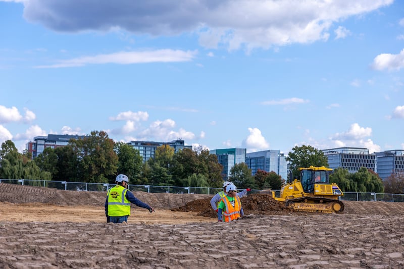 WASHINGTON, DC - OCTOBER 24: Workers build a fence as trucks unload debris and soil  from the demolition of the White House's East Wing at East Potomac Golf Course on October 24, 2025 in Washington, DC. The demolition is part of U.S. President Donald Trump's plan to build a multimillion-dollar ballroom on the eastern side of the White House. (Photo by Tasos Katopodis/Getty Images)
