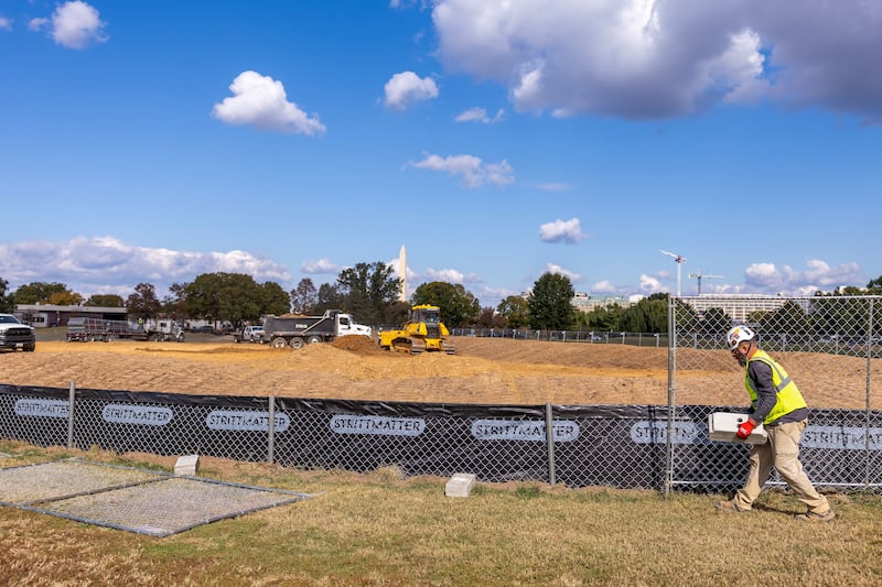 WASHINGTON, DC - OCTOBER 24: Workers build a fence as trucks unload debris and soil  from the demolition of the White House's East Wing at East Potomac Golf Course on October 24, 2025 in Washington, DC. The demolition is part of U.S. President Donald Trump's plan to build a multimillion-dollar ballroom on the eastern side of the White House. (Photo by Tasos Katopodis/Getty Images)