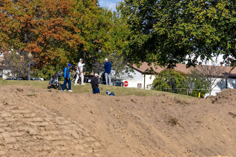 WASHINGTON, DC - OCTOBER 24: Golfers play hole six as trucks unloads debris and soil from the demolition of the White House's East Wing at East Potomac Golf Course on October 24, 2025 in Washington, DC. The demolition is part of U.S. President Donald Trump's plan to build a multimillion-dollar ballroom on the eastern side of the White House. (Photo by Tasos Katopodis/Getty Images)